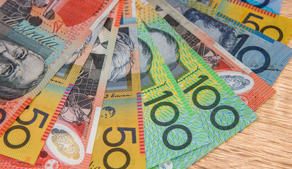 National currency. Colorful australian dollar banknotes on wooden table close up