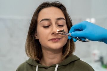 male doctor examines the nose of a patient with rhinitis.