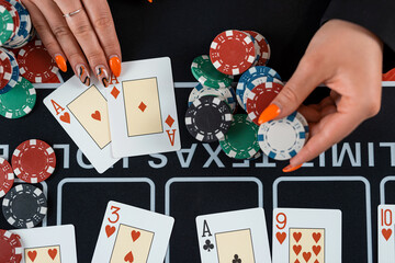 close-up female player are taking chips from the poker table at casino