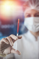 Surgeon woman doctor wearing uniform mask and gloves holding  blood at test tube in surgery clinic