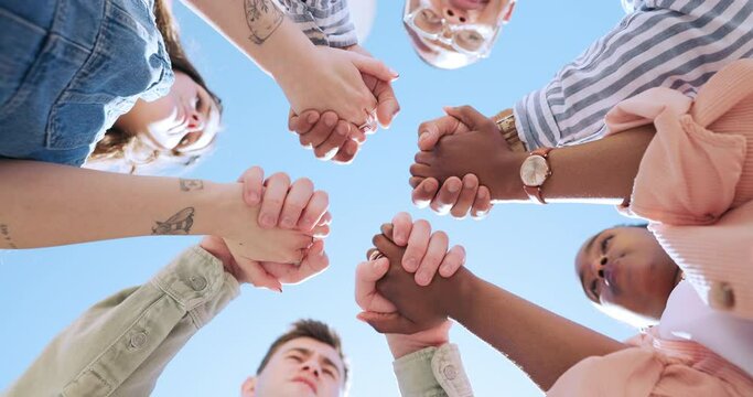 Blue sky, friends and people holding hands in circle for bonding, community and solidarity outdoors. Diversity, college campus and below of university students together for support, teamwork or trust
