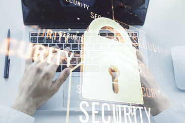 Creative idea concept with lock symbol and microcircuit illustration and hands typing on laptop on background. Protection and firewall concept. Multiexposure