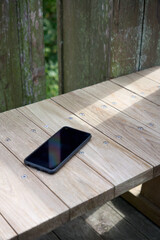屋外で木のベンチに置かれたスマートフォン