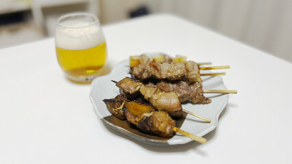 Grilled yakitori on a Japanese plate with beer