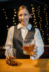 Bartender is pouring whiskey  glasses for customers beautiful night.