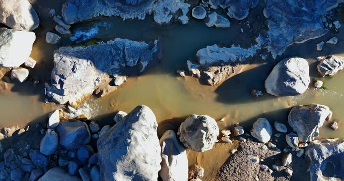 Top View River Flowing between the Rocks in Sunny Day