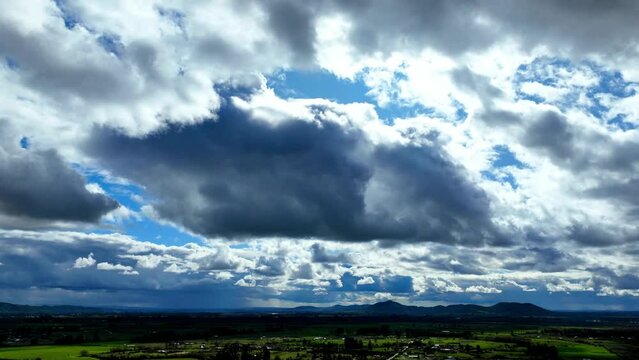 Clouds Timelapse over Green Landscape and Little Mountains in Horizon