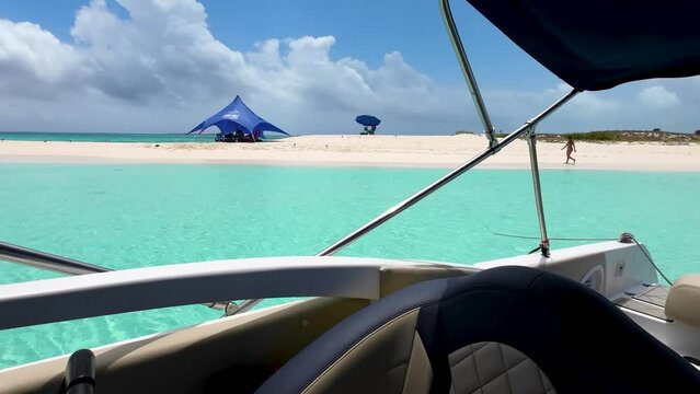 Woman walking on white sand beach seem from inside boat float on caribbean sea, Los Roques