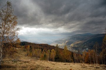 Golden autumn in the Carpathians. Mining arrays combined with trees with yellow leaves. Beautiful clouds and sun