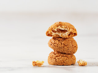 Stack of cookie amaretti on white marble background - traditional Italian Sardinian pastry. Delicious amaretti biscuit cookies made from almond or apricot kernels with copy space