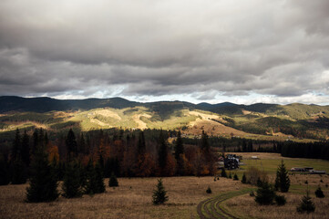 Golden autumn in the Carpathians. Mining arrays combined with trees with yellow leaves. Beautiful clouds and sun