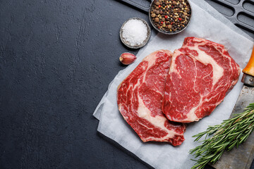 Raw ribeye steaks with savory spices