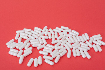 White pills on the red paper background. Epidemic virus.