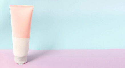 A clean label facial or body cream tube is isolated on a multi-color background. Beauty product...