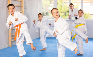 Little children in kimono standing in fight stance during group karate training