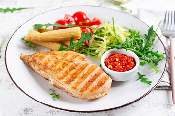 Healthy keto, ketogenic lunch with grilled chicken  breast, fillet and  salad of arugula, onion,...