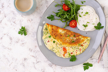Omelette with tomatoes and salad on plate. Frittata - italian omelet. Keto, ketogenic diet. Top view
