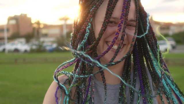 woman running and moving her hair braids with a smile