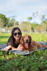 Golden Retriever and Woman Sprawled Outside on Picnic Mat
