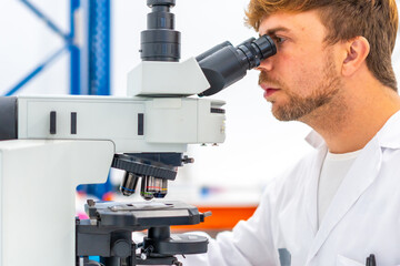 Biologist using microscope during research in laboratory