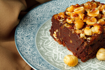 Brownie cake with chocolate and hazelnuts on plate