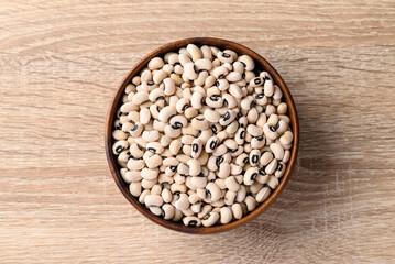 Black eye peas or cowpeas in bowl on wooden background, Food ingredients, Table top view