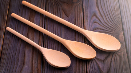 Wood spoons on wooden table. Kitchen utensils on soft sunlight