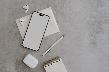 Flatlay of blank clipping path screen mobile phone, wireless earphones. Online shop, store, blog template with mockup space. Flat lay, top view