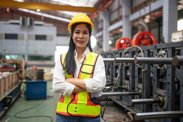 Portrait of female engineer or factory worker working in modern industrial factory, Woman looking camera in industrial factory.