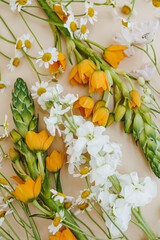 Green, white and orange flowers on beige background