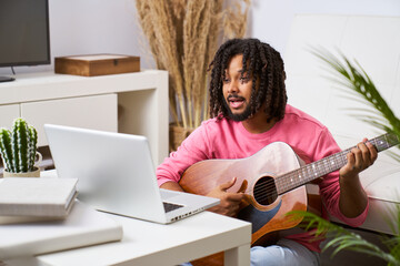 Man holding guitar take online lesson webcam on computer, music tutorial on laptop at home