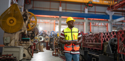 Portrait of male engineer or factory worker Wearing Hard Hat and using tablet Monitoring Production Conveyor with Tablet Computer in modern industrial factory.