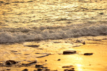 Wave splashes close-up, sunset sea background