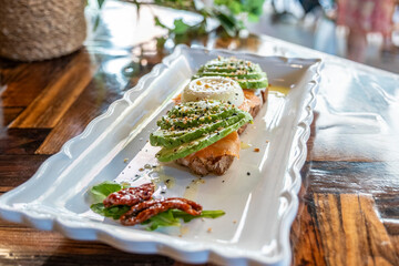Horizontal image of a Savory Delight Avocado Toast Perfection with Poached Eggs. A symphony of...