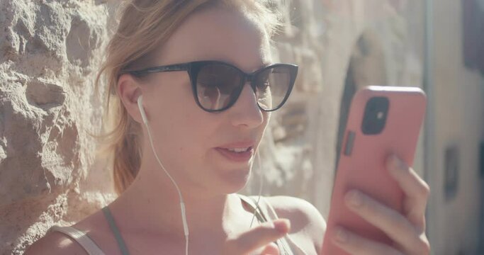Woman put smartphone headphones ear call talk smile vacation close up