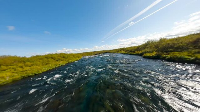 Aerial FPV shot along a fast flowing river with small waterfall in Iceland
