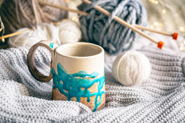 Fototapeta na wymiar Cozy composition with a cup of coffee, threads and a knitted element.