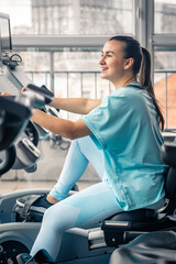Fitness woman on bicycle doing cardio workout at gym.