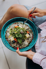 Close up of woman eating beef carpaccio with pesto sauce and parmigiano cheese. Restaurant menu