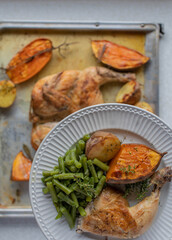 Healthy meal with oven roasted chicken and baked potatoes with rosemary and thyme