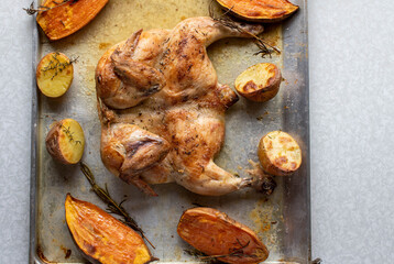 Healthy meal with oven roasted chicken and baked potatoes with rosemary and thyme