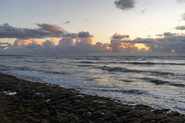 Early morning at the beach in Kauai, Hawaii, United States. the Pacific Ocean with rain clouds as...