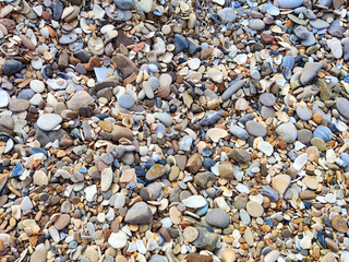 Stone background gravel. The rocky road. Fine pebbles. Construction material. The texture and pattern of the stones. Wallpaper with fine gravel. Frame, copy space and place for text