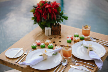 Holiday dinner setup with red decoration and welcome drinks. New Year and Festive holidays concept