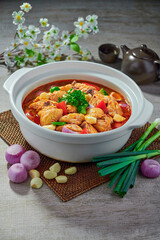 traditional chinese fried braised hot and spicy chilli tomato sauce chicken cutlet meat main course in hot soup clay pot on grey vintage background cafe hotel luxury halal food restaurant banquet menu