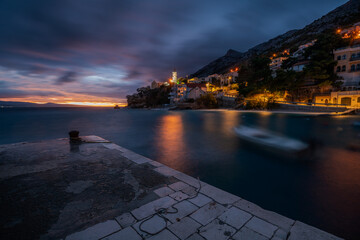 Romantic landscape of a small marina on the Makarska Riviera during a stormy evening - obrazy, fototapety, plakaty