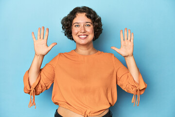 Young Caucasian woman with short hair showing number ten with hands.