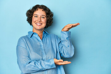 Young Caucasian woman with short hair shocked and amazed holding a copy space between hands.