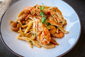 Top view of delicious dish of seafood with pasta and tomato sause served in a traditional seafood restaurant in Orebich, Croatia. © Jess_Ivanova