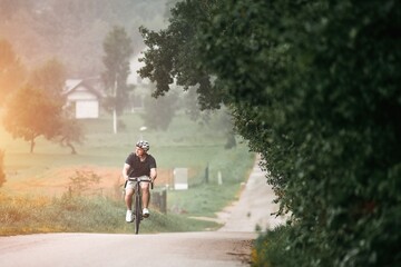 Obraz premium A silhouette of a cyclist training on a trail with a gravel bike, enjoying the adventure and the sport concept in the sunset.
